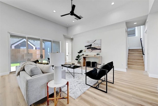 living room with ceiling fan and light hardwood / wood-style flooring