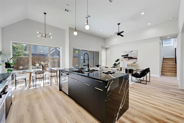 kitchen with dishwasher, sink, a spacious island, pendant lighting, and ceiling fan with notable chandelier