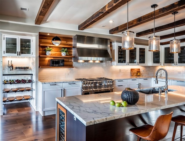 kitchen with decorative light fixtures, wall chimney exhaust hood, double oven range, tasteful backsplash, and white cabinetry