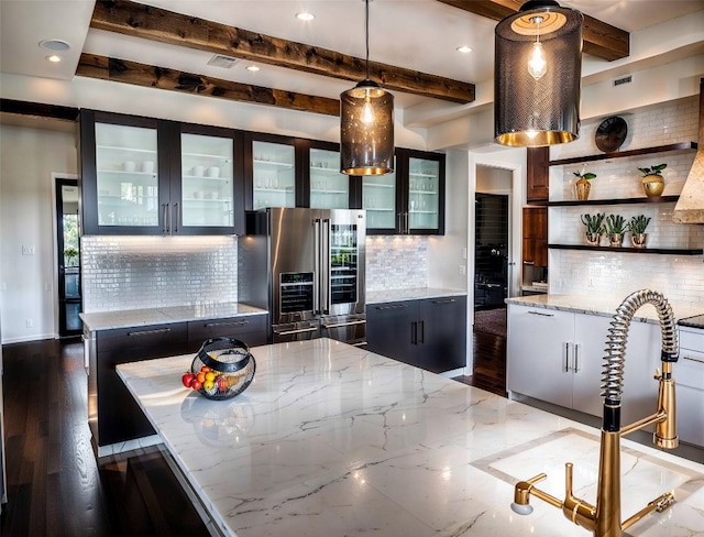 kitchen featuring high end refrigerator, beam ceiling, and tasteful backsplash