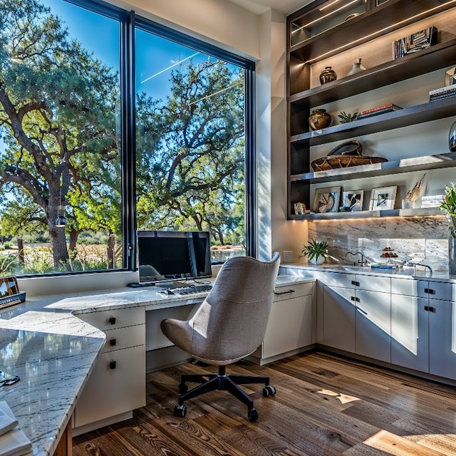 home office featuring built in desk and dark hardwood / wood-style floors