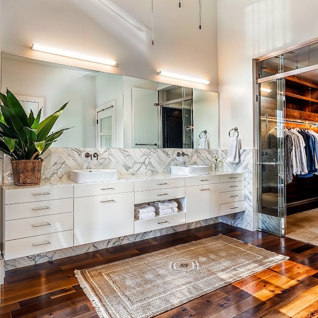 bathroom featuring vanity, wood-type flooring, and decorative backsplash