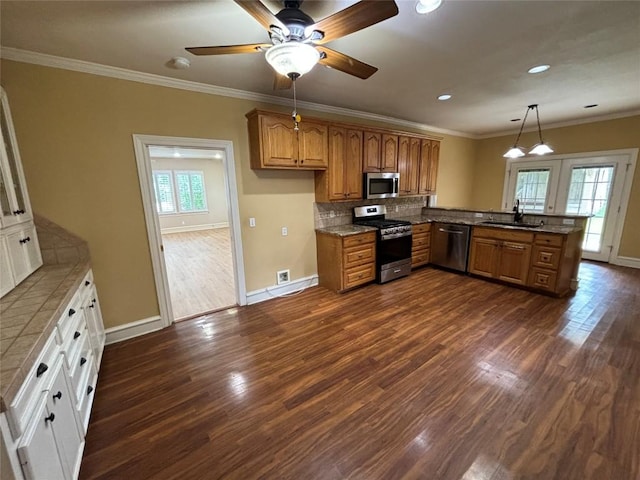 510 S Church St, Georgetown, TX 78626 - kitchen with stainless steel appliances, a peninsula, brown cabinetry, dark wood-style flooring, and backsplash