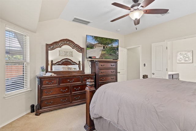 carpeted bedroom with ceiling fan, ensuite bathroom, and vaulted ceiling