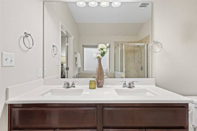 bathroom featuring vanity, lofted ceiling, toilet, and a shower with shower door