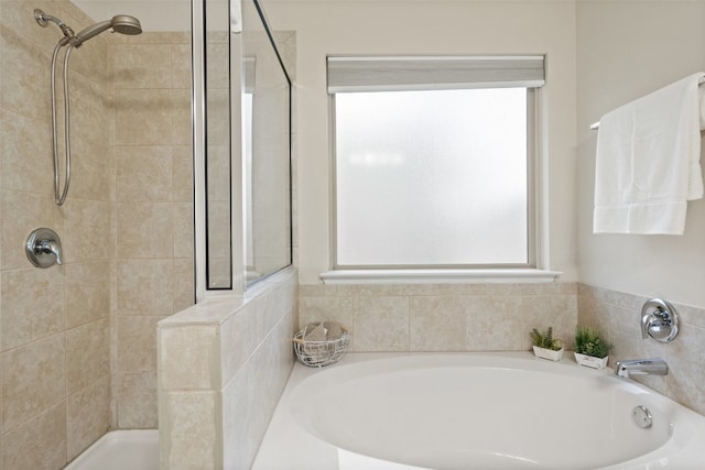 bathroom featuring shower with separate bathtub