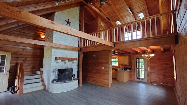 unfurnished living room with hardwood / wood-style floors, high vaulted ceiling, wood ceiling, and a fireplace