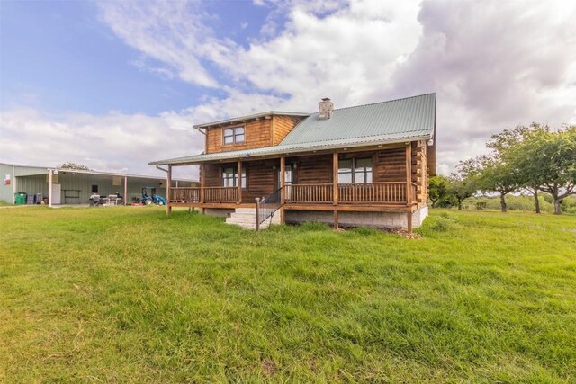 rear view of property with a yard and covered porch