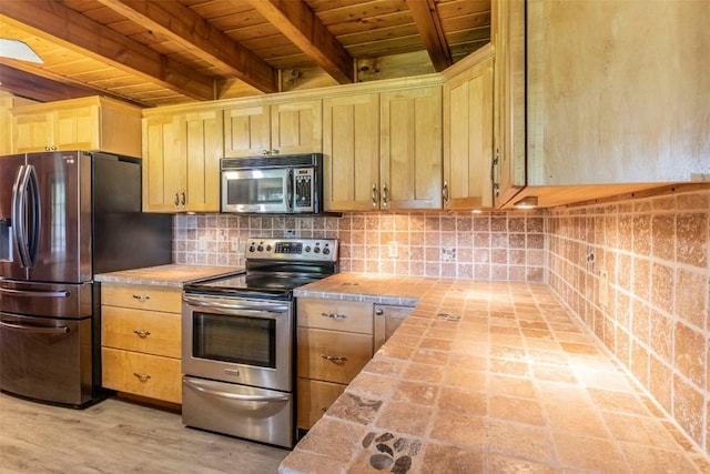 kitchen featuring wooden ceiling, appliances with stainless steel finishes, beam ceiling, decorative backsplash, and light brown cabinetry