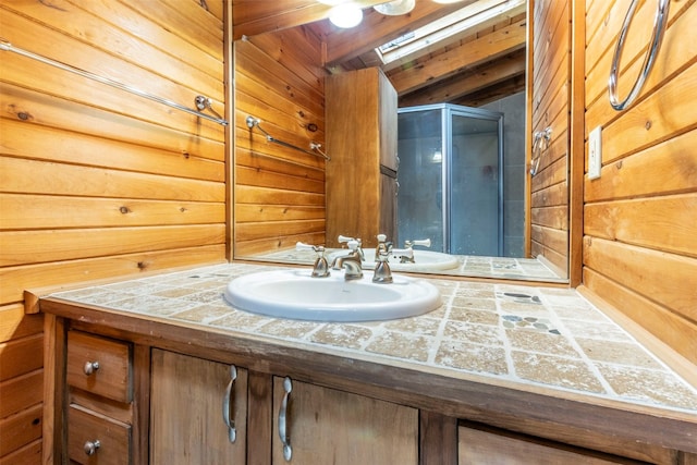 bathroom with lofted ceiling, vanity, a shower with shower door, and wood walls