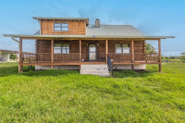 back of property with covered porch, a chimney, log siding, and metal roof