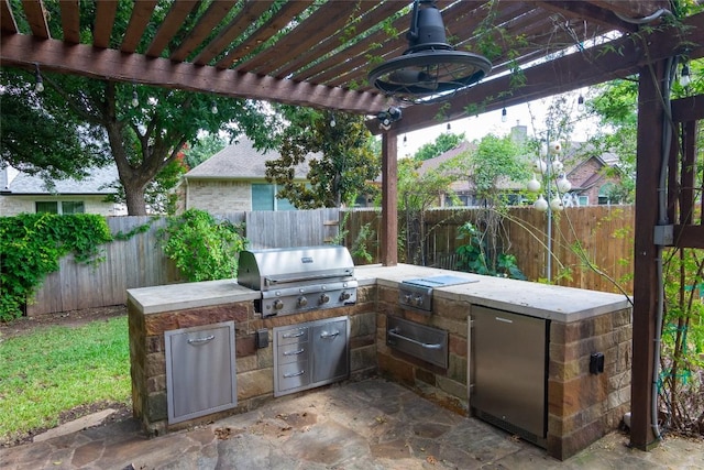 view of patio with a grill, a pergola, and exterior kitchen