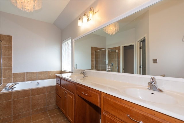 bathroom featuring an inviting chandelier, vaulted ceiling, vanity, plus walk in shower, and tile patterned flooring