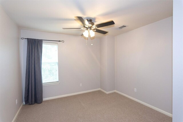 empty room featuring ceiling fan and carpet