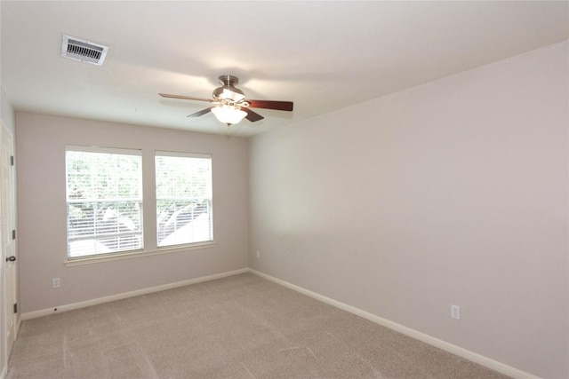 spare room featuring light colored carpet and ceiling fan