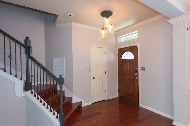 entryway with dark wood-type flooring, ornamental molding, and decorative columns