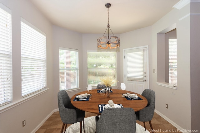 tiled dining room featuring an inviting chandelier