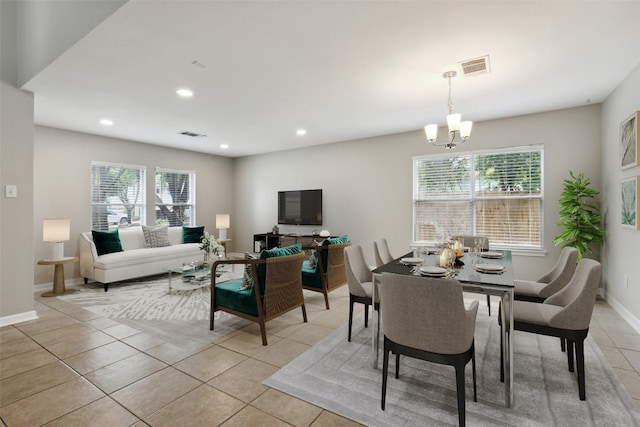 dining area featuring a healthy amount of sunlight, a notable chandelier, and light tile patterned floors