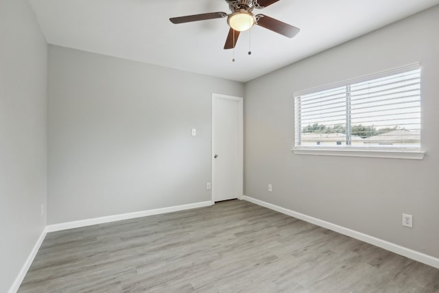 empty room with ceiling fan and light hardwood / wood-style floors