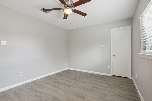 empty room with ceiling fan and hardwood / wood-style floors