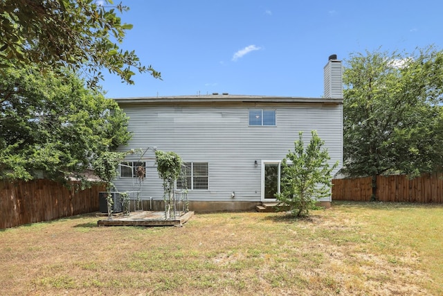 back of property featuring a lawn and a wooden deck