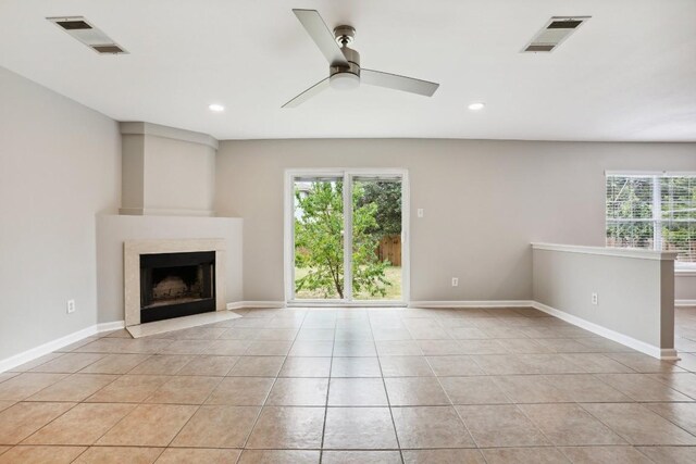 unfurnished living room featuring a wealth of natural light, light tile patterned floors, and ceiling fan