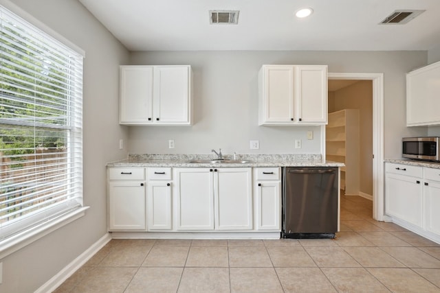 kitchen featuring white cabinets, light stone countertops, stainless steel appliances, and sink