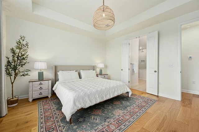 bedroom featuring hardwood / wood-style flooring and a tray ceiling