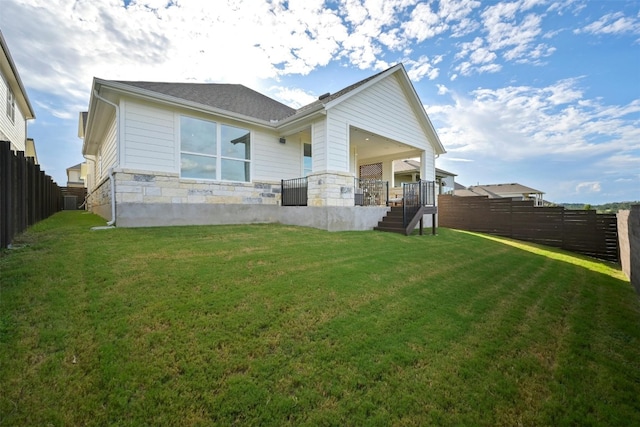 rear view of property featuring a lawn