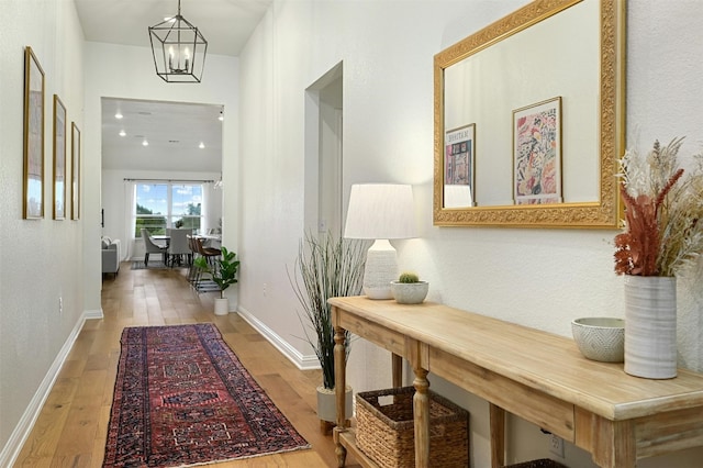 hall featuring hardwood / wood-style flooring and a chandelier