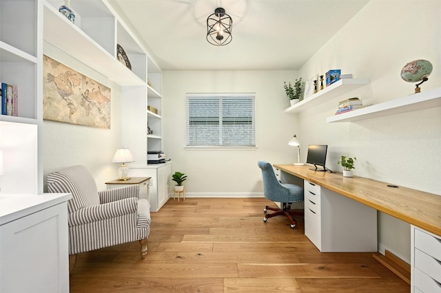 office area with built in desk and light hardwood / wood-style flooring