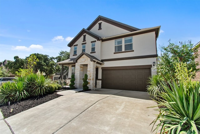 view of front of property featuring an attached garage, concrete driveway, stone siding, and stucco siding