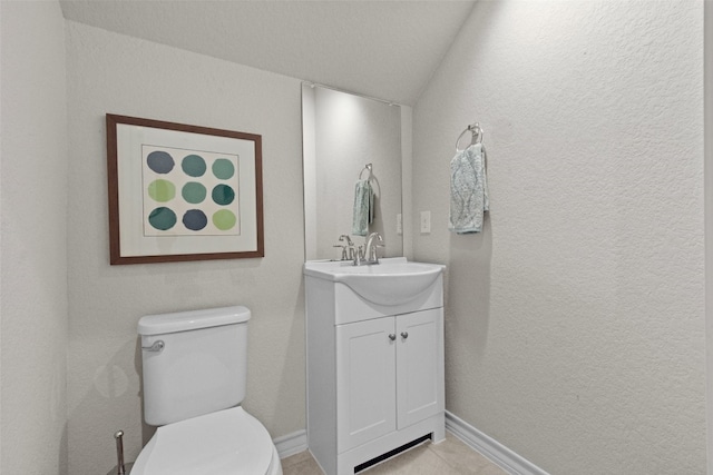 bathroom with toilet, vanity, and vaulted ceiling