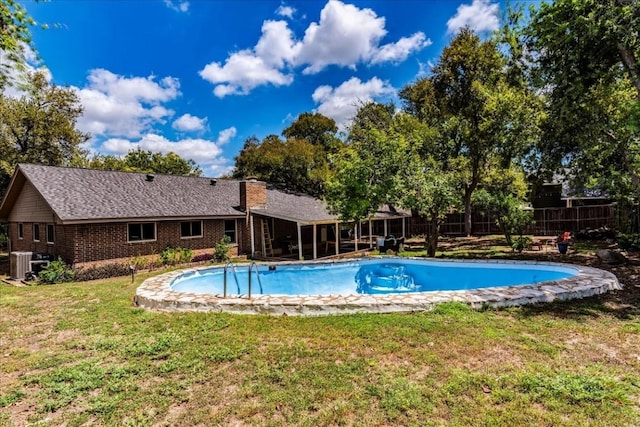 view of swimming pool with a fenced in pool, a yard, fence, and central AC unit