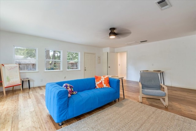 living room with light hardwood / wood-style flooring and ceiling fan