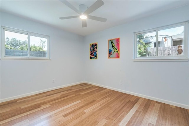 empty room with a ceiling fan, light wood-type flooring, and baseboards