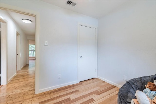 unfurnished room with light wood-type flooring, visible vents, and baseboards