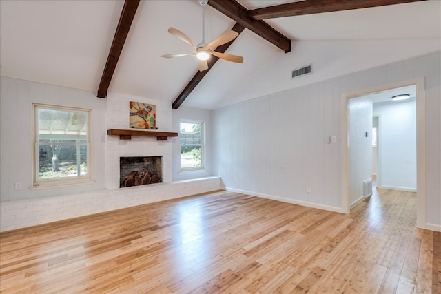 unfurnished living room with lofted ceiling with beams, a fireplace, ceiling fan, and light hardwood / wood-style floors