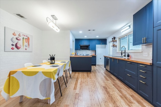 kitchen with decorative backsplash, sink, light wood-type flooring, and blue cabinetry