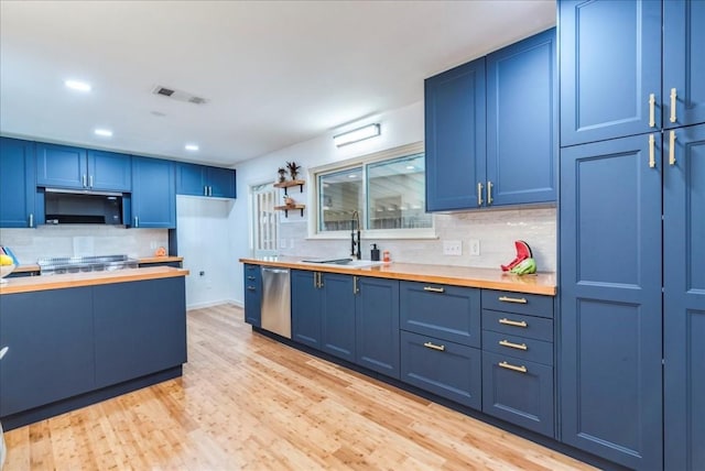 kitchen with blue cabinets, stainless steel dishwasher, visible vents, and a sink