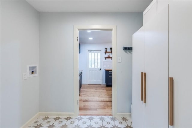 hallway with baseboards and light floors