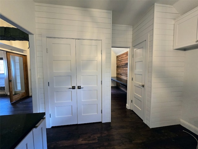 interior space with wood-type flooring and wooden walls