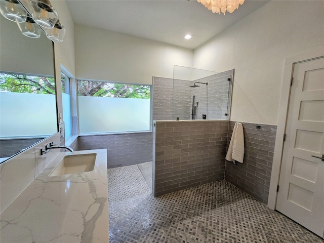 bathroom featuring tiled shower, vanity, tile walls, and tile patterned flooring