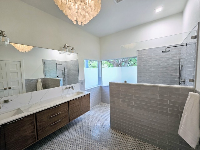 bathroom with tile patterned floors, tiled shower, and vanity