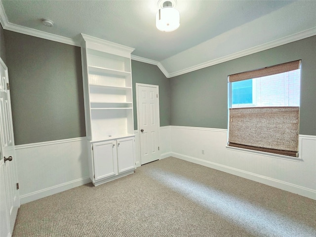 carpeted spare room featuring lofted ceiling and ornamental molding