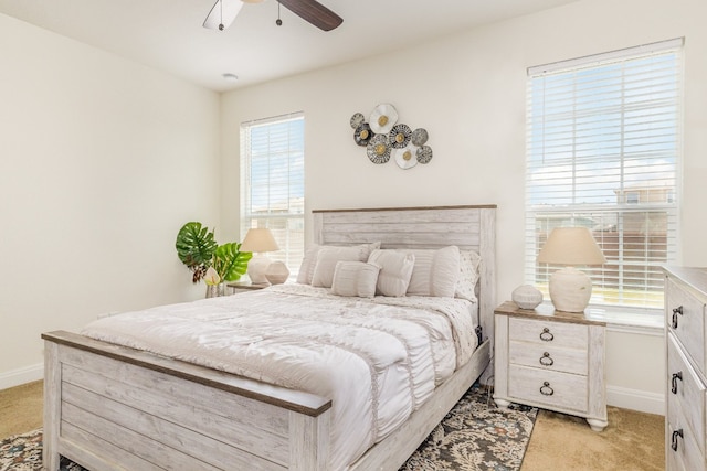 carpeted bedroom featuring multiple windows and ceiling fan