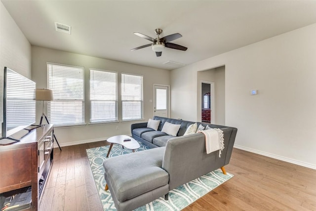 living area featuring ceiling fan, baseboards, wood finished floors, and visible vents
