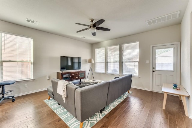 living room with wood-type flooring, visible vents, and ceiling fan