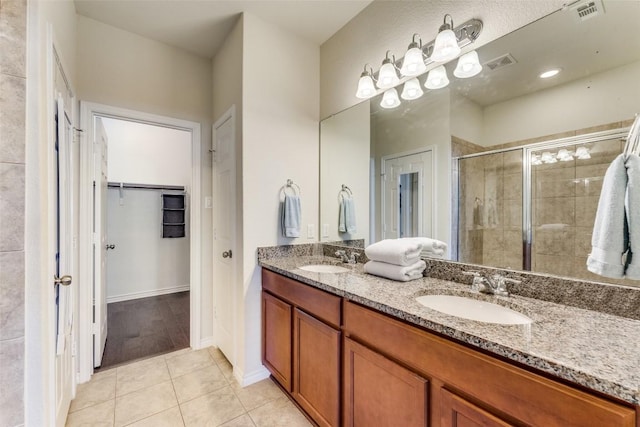 bathroom featuring vanity, tile patterned floors, and a shower with shower door