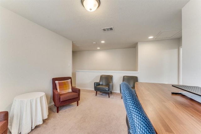 sitting room with visible vents, attic access, light colored carpet, and recessed lighting